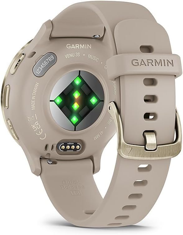A close-up of the Garmin Venu 3S smartwatch with a gold steel bezel and French gray case, displaying a heart rate reading on its bright, colorful screen, worn on a wrist.