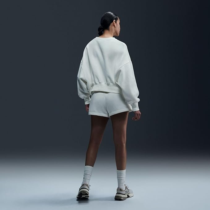 Nike Women's Phoenix Oversized Crewneck Sweatshirt – Soft Fleece, Casual & Trendy for Daily Wear A woman wearing the Nike Sportswear Phoenix Fleece oversized crewneck in Sail/Black, paired with leggings, standing in a relaxed pose that highlights the dropped shoulder seams and relaxed fit.