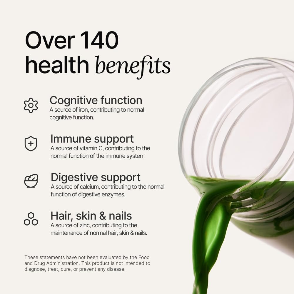 A glass of vibrant green Huel Daily Greens next to the original bag and a clear Huel bottle, with fresh apples and mint leaves in the background.