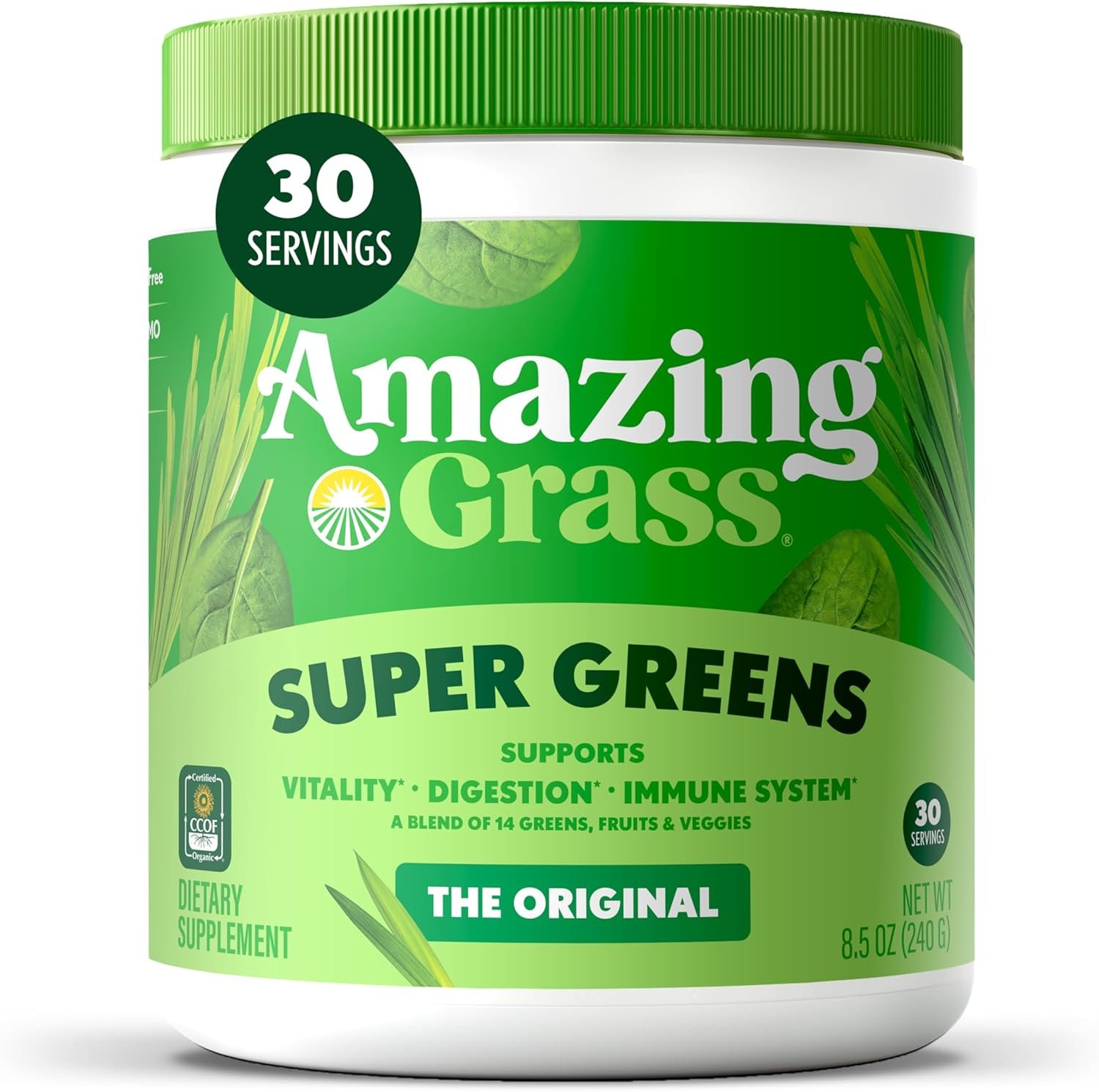 A glass of vibrant green Amazing Grass Green Superfood drink is next to the green bag, with fresh spinach, kale, and an apple in the background, emphasizing the natural ingredients.
