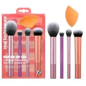 The Real Techniques A 5-piece Everyday Essentials makeup brush set laid flat, featuring four makeup brushes and one orange Miracle Complexion Sponge on a clean white background.